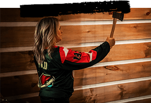 A woman holds an axe about to throw at this axe throwing Detroit venue.