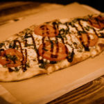 Margherita Flatbread Pizza served on a wooden tray.